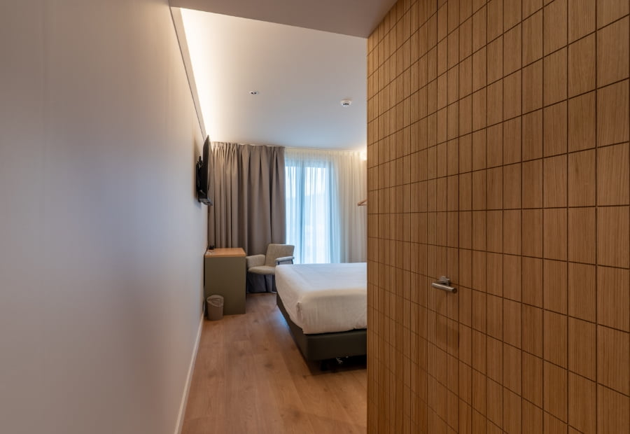 Habitación doble con escritorio, sillón y televisión