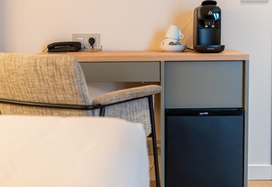 Habitación triple superior detalle cafetera, teléfono y mini nevera