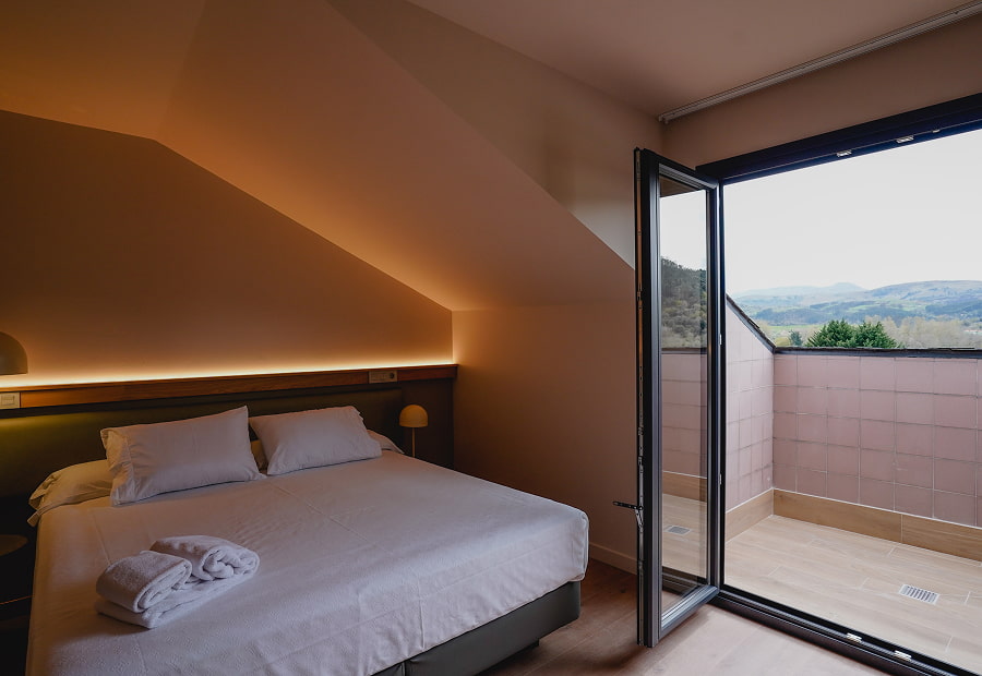 Habitación triple superior con cama King size y balcón con vistas a la montaña