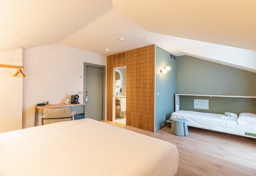 Habitación triple superior con cama supletoria, escritorio y amenities